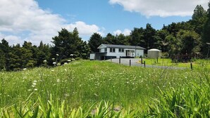 A house with a fenced yard and a water tank in the background.