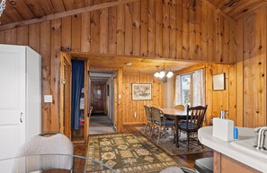 L’intérieur d’une cabane en bois comprend un coin repas, une cuisine et une salle de bain.