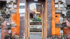 A traditional Balinese gate with intricate carvings and a lion statue. - Pande Permai Guest House (Ubud)