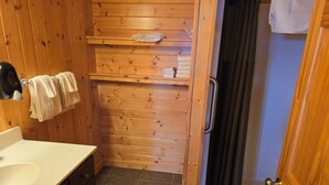 A wooden bathroom with a sink, towel rack, and a shower area. - Lake Superior Log Cabin - Wake up to Waves! (Lutsen)
