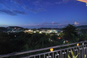 Une vue d’une zone de villégiature avec un grand bâtiment, une végétation luxuriante et un ciel dégagé.