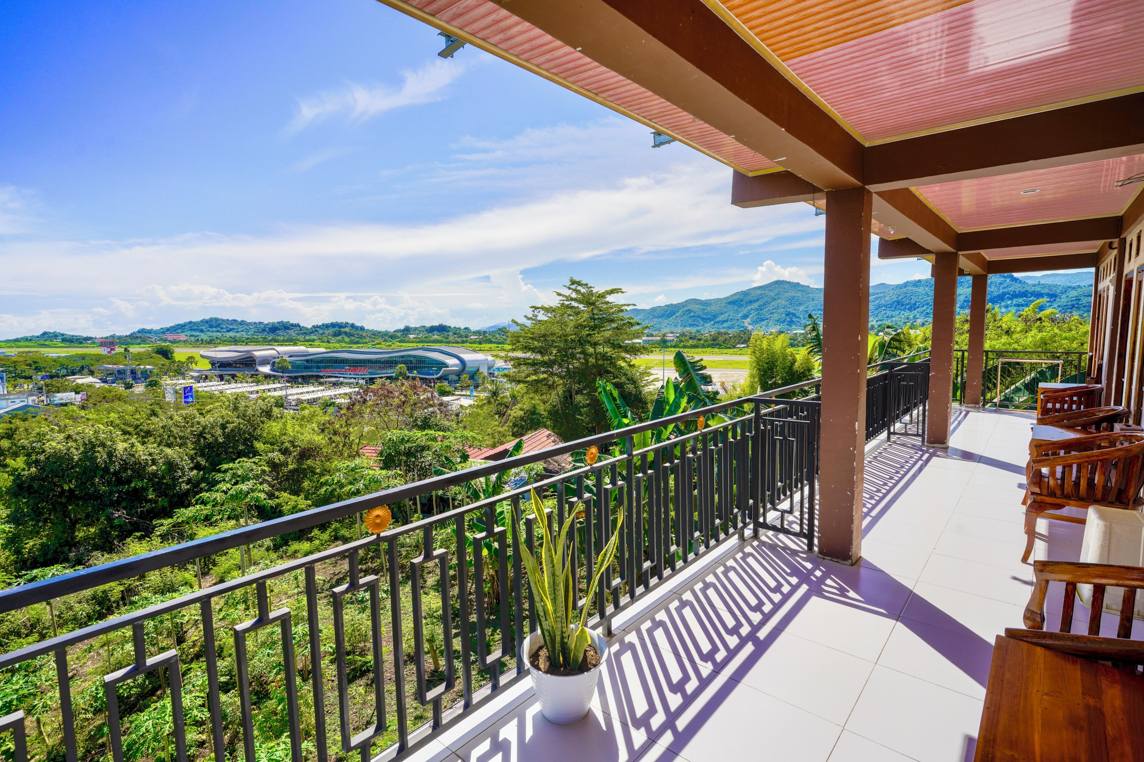 Ein Balkon mit Blick auf ein modernes Gebäude und üppiges Grün.