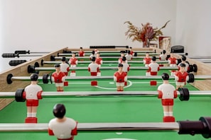 Ein Kicker mit mehreren Spielern in roten und weißen Trikots.