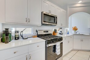 A modern kitchen with white cabinetry, a stainless steel stove, and a microwave above it. - Comfy Stay7 Beds| Close to Strip & Attraction (Enterprise)