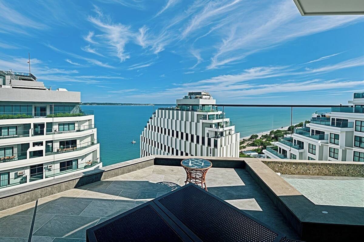 Ein modernes Gebäude mit Dachterrasse und Blick auf ein Gewässer.