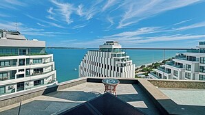 Un edificio moderno con terrazza sul tetto affacciata su un corpo d'acqua.