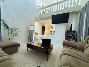 A living room with a sofa, a coffee table with a laptop, a TV mounted on the wall, and a staircase leading to another level. - Ground floor house with gym and terraces (La Paz)