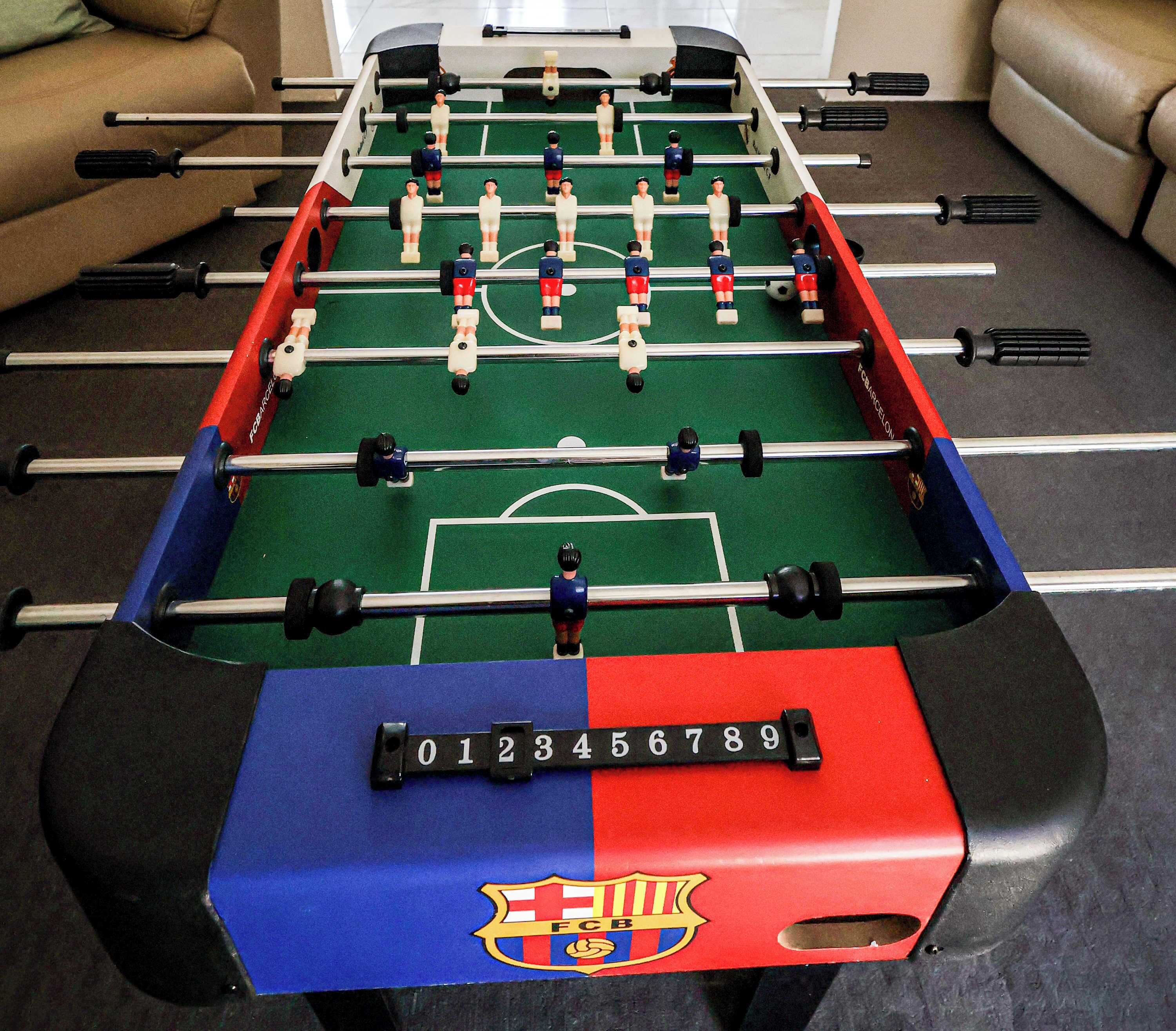 Un baby-foot orné du logo du FC Barcelone et doté de cases de marquage numérotées.
