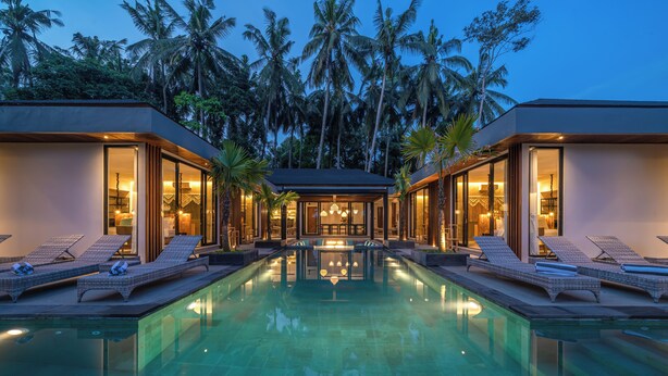 A modern resort with a central pool, lounge areas, and a view of palm trees. - Kiena Ubud (Ubud)