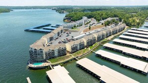 A waterfront hotel with multiple buildings, a dock, and a boat.