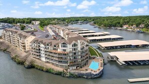 A waterfront hotel with multiple buildings, a dock area, and a swimming pool.