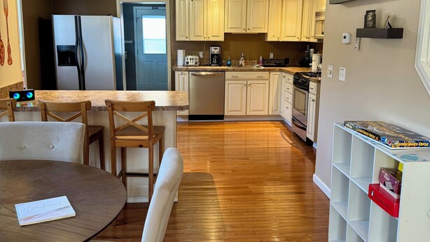 A modern kitchen with wooden flooring, a dining area with a round table and chairs, and built-in cabinetry. - Charming 2 BR Whole-house rental Explore Historic Bethlehem (Bethlehem)