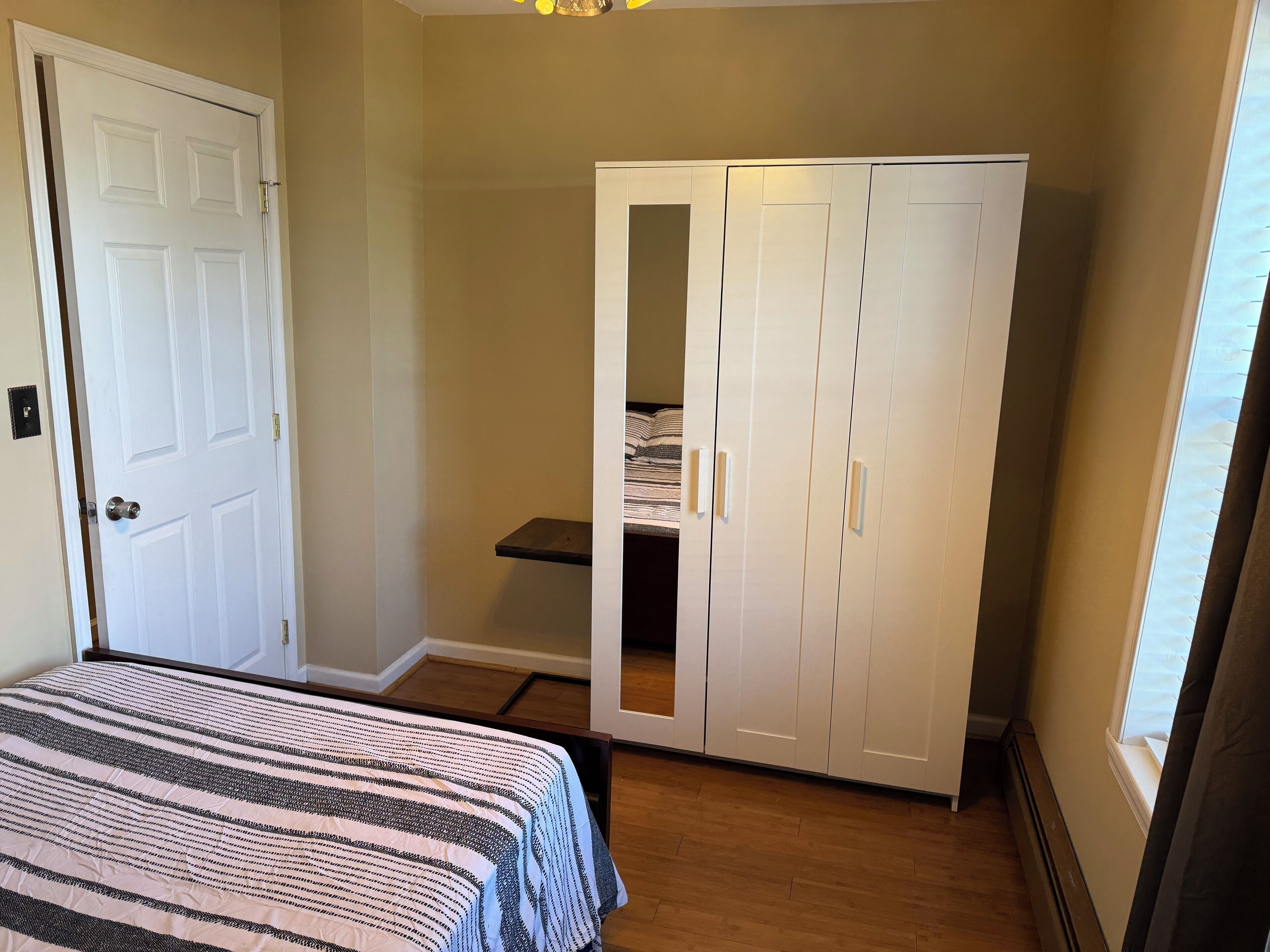 Ein Schlafzimmer mit einem Bett, einem Kleiderschrank und einem Fenster.