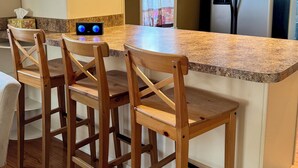 A kitchen with a wooden island, bar stools, a refrigerator, and a window with a view. - Charming 2 BR Whole-house rental Explore Historic Bethlehem (Bethlehem)