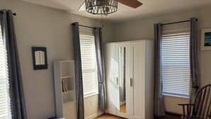 A bedroom with a bed, wardrobe, and a rocking chair. - Charming 2 BR Whole-house rental Explore Historic Bethlehem (Bethlehem)