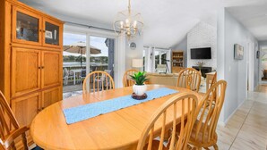 Un comedor con una mesa de madera, sillas y un candelabro.