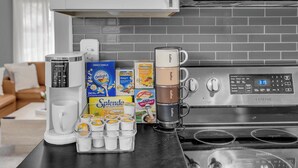 Una cucina con una macchina da caffè, tazze e diverse cialde.