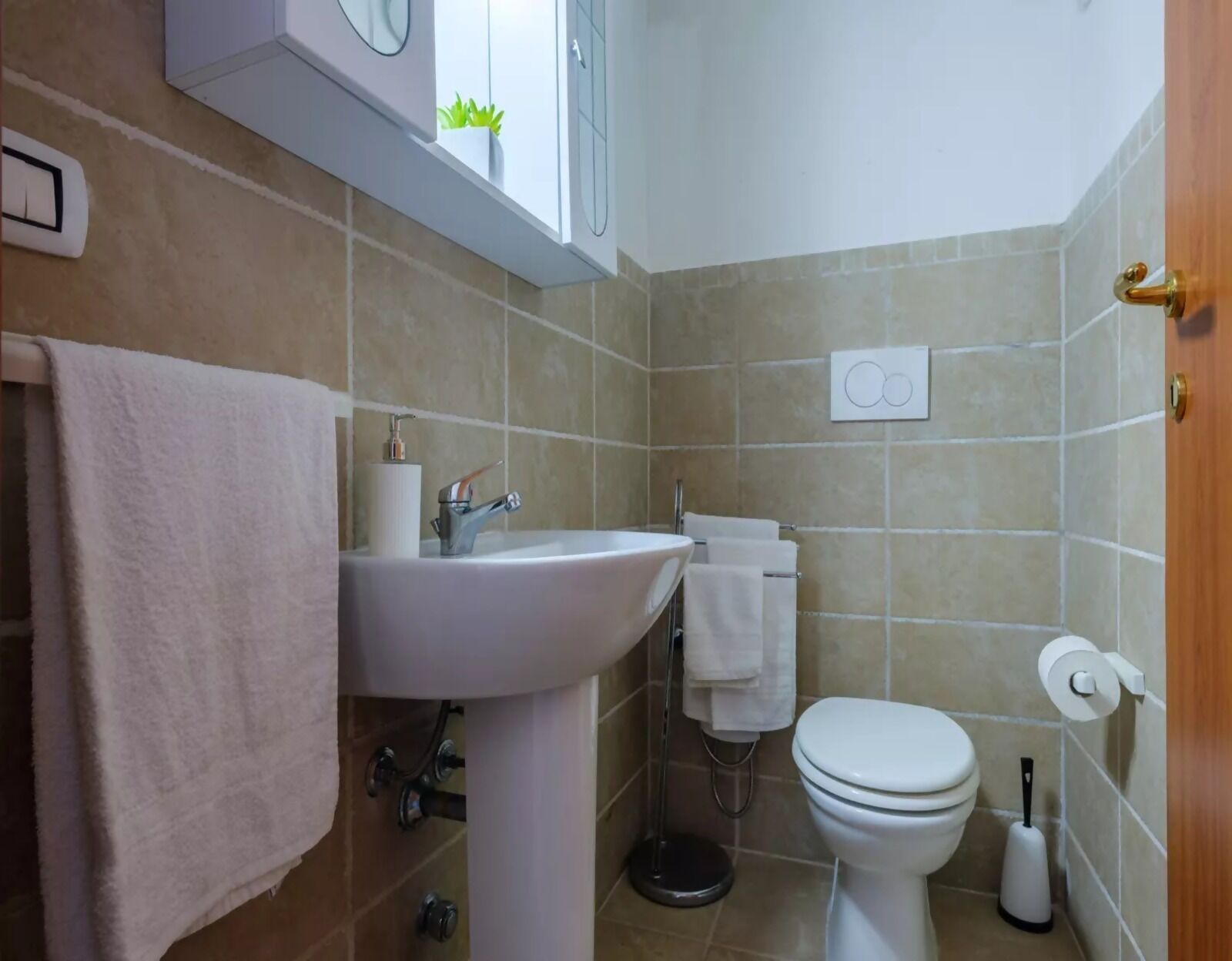 A bathroom with a sink, toilet, and a towel rack.