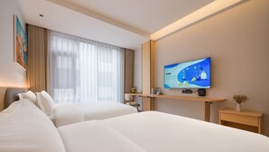 A hotel room with two beds, a TV on the wall, a desk, and a window with curtains. - Yixinju Holiday Homestay (Zhangjiajie)