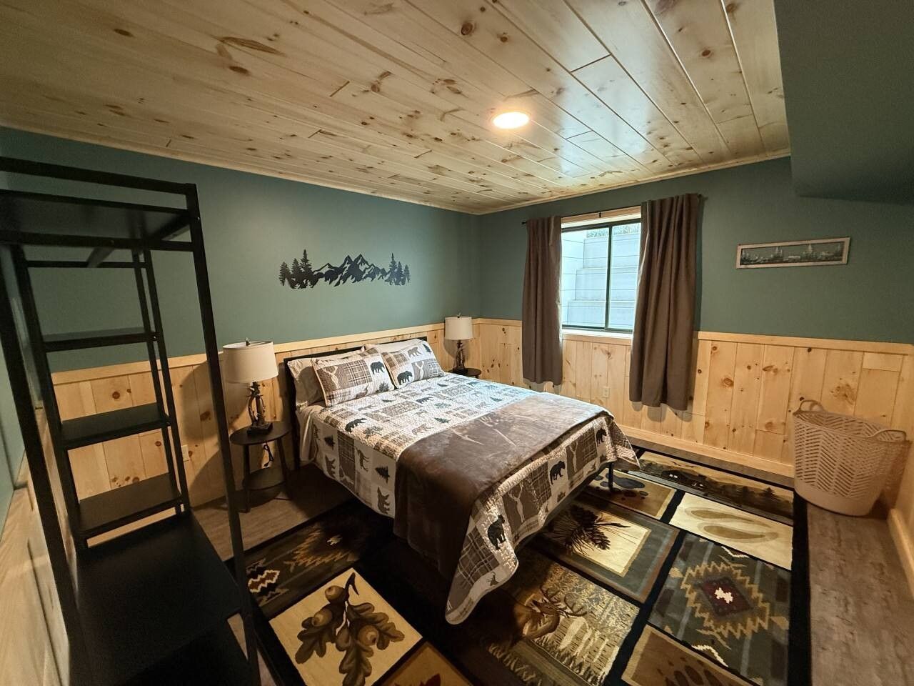 Quarto com cama, escada, janela com cortinas e quadro na parede.
