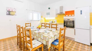 A compact kitchen with white cabinets, a built-in oven, and a white refrigerator. - Holiday apartment mit Klimaanlage (Medulin)