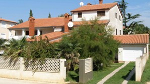 A two-story house with a red-tiled roof, white walls, and a satellite dish. - Holiday apartment mit Klimaanlage (Medulin)