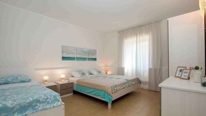 Una camera da letto con un letto, comodini, un tavolino e una cassettiera.