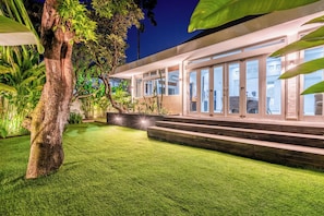 A modern house with a well-maintained lawn and a large tree. - Villa Olimpia (By JB Villas) (Kuta)