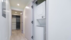 A hallway with a white laundry machine, a closet with a sliding door, and a light-colored floor. - New Vancouver Kerrisdale Suite mins to Yvr/Ubc (Vancouver)