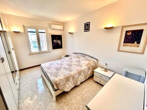 Ein Schlafzimmer mit einem Bett, Nachttisch und Fenster.