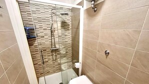 A modern bathroom with a glass-enclosed shower, a toilet, and a sink. - Large quadrilo with p.auto and a/c near the sea (Marcelli)