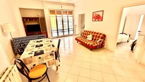 A living room with a dining table, sofa, and a ceiling fan. - Large quadrilo with p.auto and a/c near the sea (Marcelli)