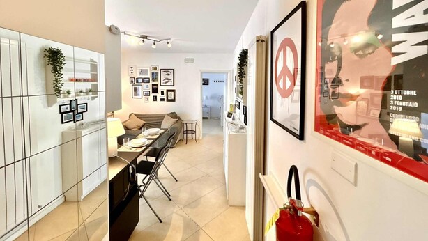 Eine moderne Küche mit Essbereich, weißen Schränken und einem an der Wand befestigten Feuerlöscher.