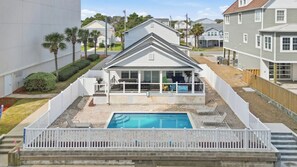 A two-story house with a covered patio and a swimming pool. - White Lotus Beach Retreat w Pool and Ocean Peek (North Myrtle Beach)