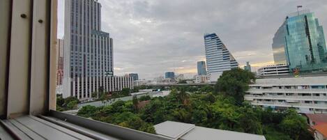 A cityscape with modern high-rise buildings, a mix of greenery, and a clear sky.