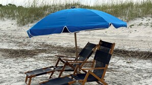 A beach scene with a blue umbrella and wooden beach chairs. - Marriott Surfwatch - OCEANFRONT (Hilton Head Island)