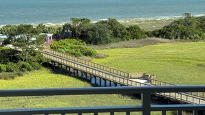 A wooden boardwalk leading to a beach, surrounded by greenery and a view of the ocean. - Marriott Surfwatch - OCEANFRONT (Hilton Head Island)