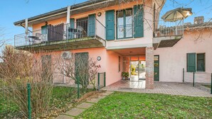 A two-story building with a balcony, a door, and a window. - Cosy House Serena- Park & Shared Pool (Puegnago del Garda)