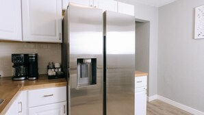 A stainless steel refrigerator with a water dispenser, a coffee maker, and a microwave on a wooden countertop. - Updated 3 Bedroom Charmer (Kelso)