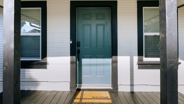 A front door with a welcome mat, a small porch, and a window with blinds. - Updated 3 Bedroom Charmer (Kelso)