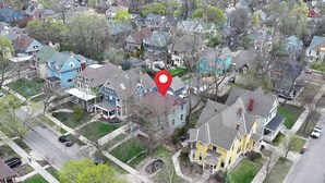 An aerial view of a residential neighborhood with houses, streets, and a red location marker. - Classic Heritage Hill Remodeled 2 Bedroom with Bold and Warm Colors (Grand Rapids)