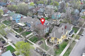 An aerial view of a residential neighborhood with houses, streets, and a red location marker. - Classic Heritage Hill Remodeled 2 Bedroom with Bold and Warm Colors (Grand Rapids)