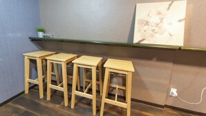 A room with a wooden floor, a green shelf with a small plant, and a wall-mounted picture. - Cozy Modern Apartment | Walk to Tanimachi & Easy Access to Namba & Osaka Castle (Osaka-cty,Tennoujiku,Shimizudani-chou)
