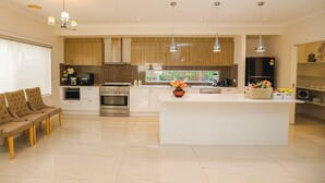 Une cuisine moderne dotée d’un îlot central, de meubles en bois et de luminaires suspendus.