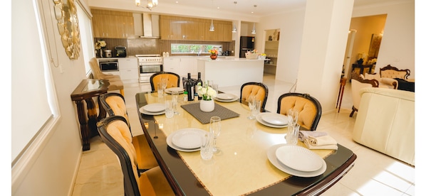 A dining area with a table set for four, surrounded by chairs.