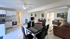 A modern apartment with a kitchen, dining area, living room, and a balcony. - Chloes Waterfront Oasis ~ A modern apartment with open plan living (Sussex Inlet)