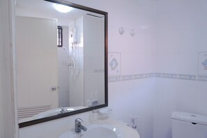 A bathroom with a white sink, a mirror, a toilet, and a shower. - GO INN Patong Beach (Patong)