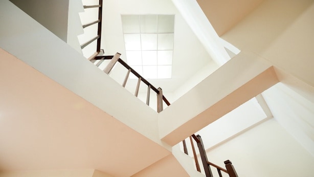 Eine moderne Treppe mit Holzgeländer und weißen Wänden.