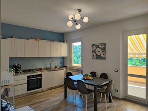 Eine moderne Küche mit Essbereich, Holdekor-Schränken, einem Gasherd und einem Esstisch mit Stühlen.