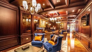 Eine luxuriöse Lobby mit bequemen Sitzgelegenheiten, Holzwänden und stilvollen Kronleuchtern.